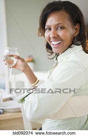 Picture - Black woman drinking white wine. Fotosearch