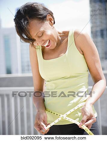 Black woman measuring her waistline View Large Photo Image Stock Photography - Black woman measuring her waistline. Fotosearch