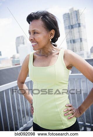 Stock Photo - Black woman on urban balcony. Fotosearch