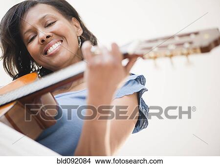 Picture - Black woman playing guitar. Fotosearch