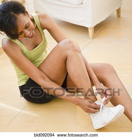 Black woman putting on athletic shoes View Large Photo Image Picture - Black woman putting on athletic shoes. Fotosearch