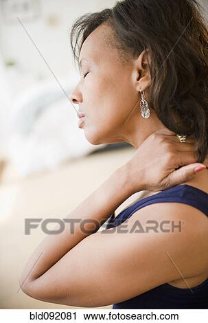 Black woman rubbing her neck View Large Photo Image Stock Image - Black woman rubbing her neck. Fotosearch