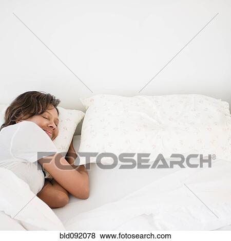 Stock Photo - Black woman sleeping in bed. Fotosearch