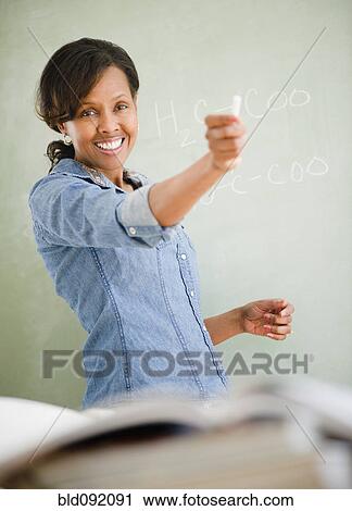 Stock Image - Black woman teaching in classroom. Fotosearch
