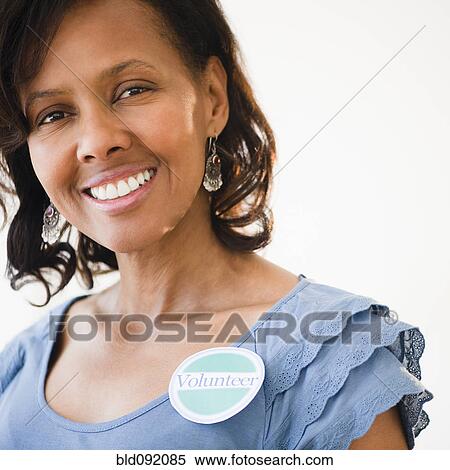 Stock Photography - Black woman wearing volunteer badge. Fotosearch