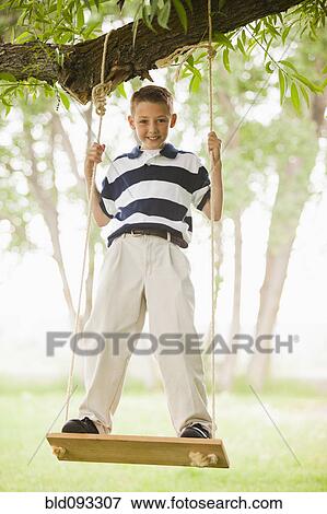 Caucasian boy swinging on swing View Large Photo Image Stock Photo - Caucasian boy swinging on swing. Fotosearch