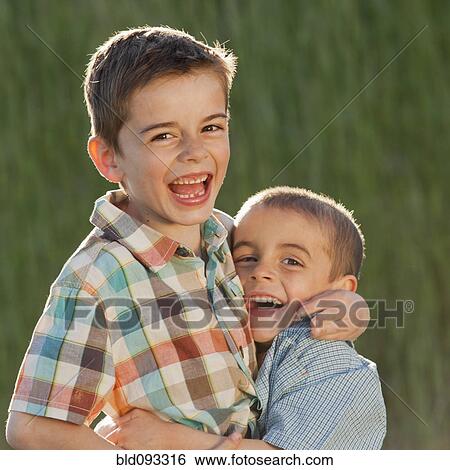Stock Photograph - Caucasian brothers hugging. Fotosearch