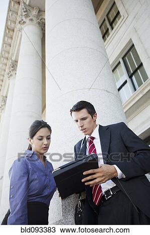 Stock Image - Caucasian business people looking at digital tablet. Fotosearch