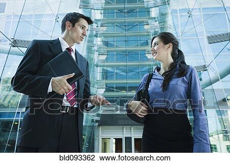 Stock Image - Caucasian business people talking together outdoors. Fotosearch