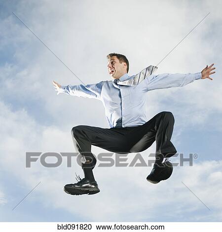 Stock Image - Caucasian businessman jumping in air. Fotosearch