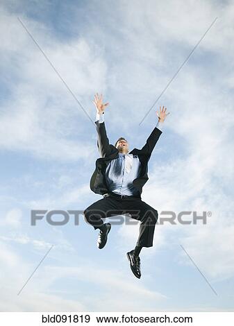 Stock Photo - Caucasian businessman jumping in air. Fotosearch