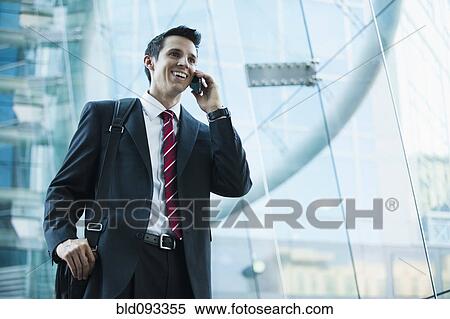 Stock Photography - Caucasian businessman talking on cell phone outdoors. Fotosearch
