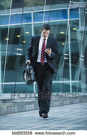 Caucasian businessman text messaging on cell phone outdoors View Large Photo Image Stock Photo - Caucasian businessman text messaging on cell phone outdoors. Fotosearch