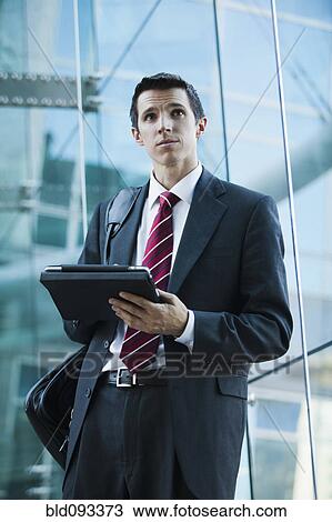 Stock Image - Caucasian businessman using digital tablet. Fotosearch