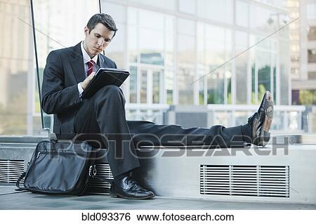 Stock Photograph - Caucasian businessman using digital tablet. Fotosearch
