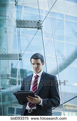 Stock Photography - Caucasian businessman using digital tablet. Fotosearch