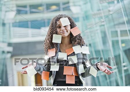 Picture - Caucasian businesswoman covered in sticky notes. Fotosearch