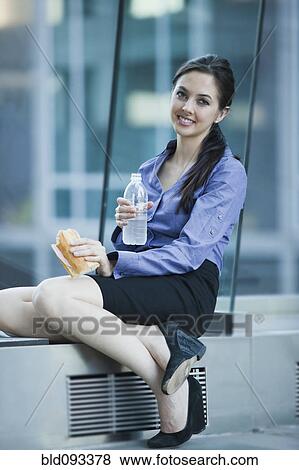 Stock Photo - Caucasian businesswoman eating lunch. Fotosearch