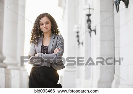 Stock Photograph - Caucasian businesswoman standing outdoors with arms crossed. Fotosearch