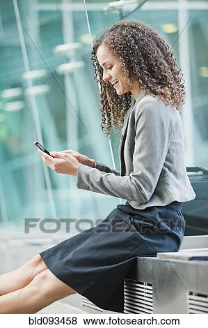 Stock Photo - Caucasian businesswoman text messaging on cell phone. Fotosearch