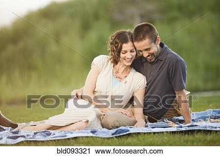 Stock Image - Caucasian couple enjoying picnic. Fotosearch