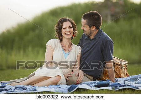 Stock Image - Caucasian couple enjoying picnic. Fotosearch