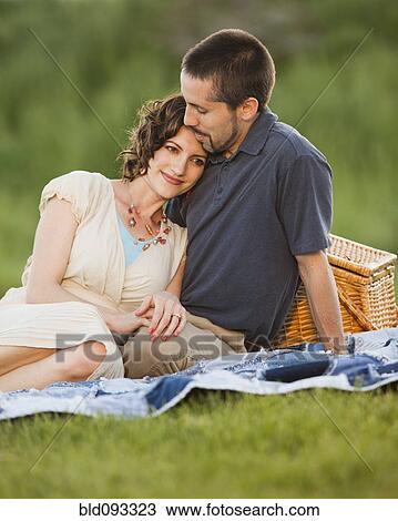 Stock Image - Caucasian couple enjoying picnic. Fotosearch