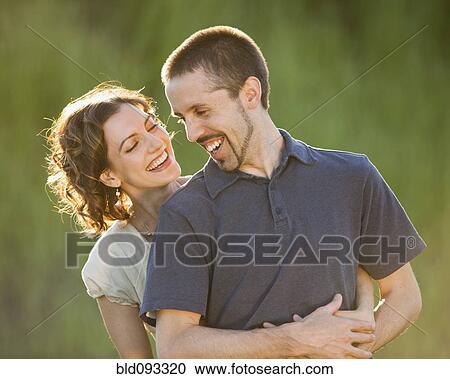 Stock Image - Caucasian couple hugging outdoors. Fotosearch