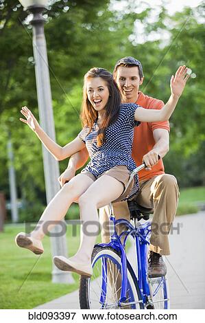 Caucasian couple riding bicycle together View Large Photo Image Stock Photo - Caucasian couple riding bicycle together. Fotosearch