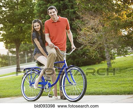 Caucasian couple riding bicycle together View Large Photo Image Stock Photo - Caucasian couple riding bicycle together. Fotosearch