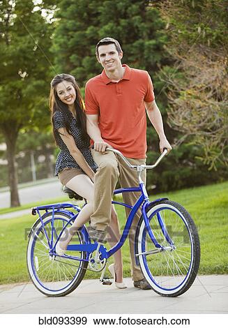 Caucasian couple riding bicycle together View Large Photo Image Stock Photo - Caucasian couple riding bicycle together. Fotosearch