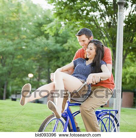 Caucasian couple riding bicycle together View Large Photo Image Stock Photograph - Caucasian couple riding bicycle together. Fotosearch
