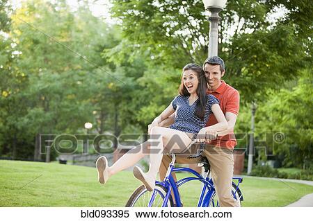 Stock Photography - Caucasian couple riding bicycle together. Fotosearch