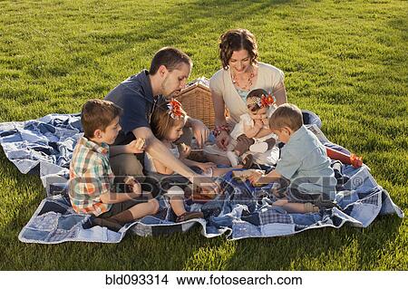 Picture - Caucasian family enjoying picnic. Fotosearch