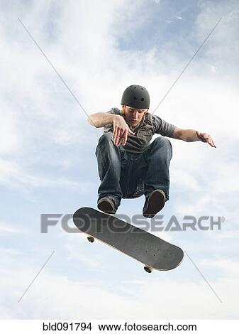 Caucasian man on skateboard in mid-air View Large Photo Image Picture - Caucasian man on skateboard in mid-air. Fotosearch