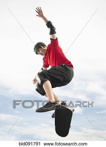 Caucasian man on skateboard in mid-air View Large Photo Image Stock Image - Caucasian man on skateboard in mid-air. Fotosearch