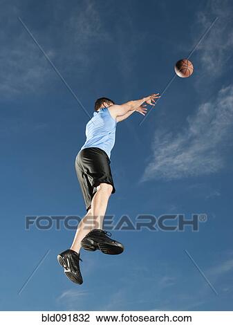Stock Image - Caucasian man playing basketball. Fotosearch