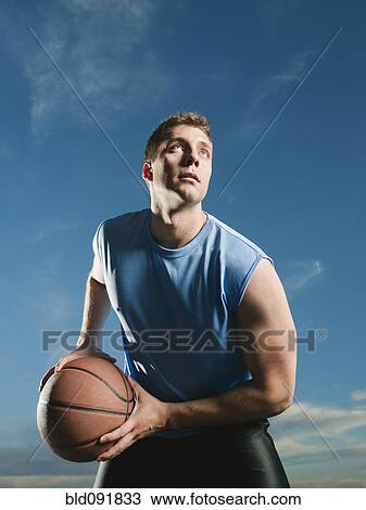 Stock Image - Caucasian man playing basketball. Fotosearch