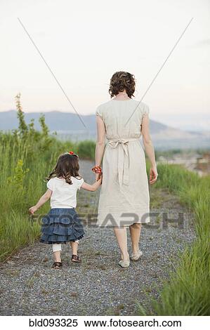 Caucasian mother and daughter walking on path View Large Photo Image Stock Photography - Caucasian mother and daughter walking on path. Fotosearch