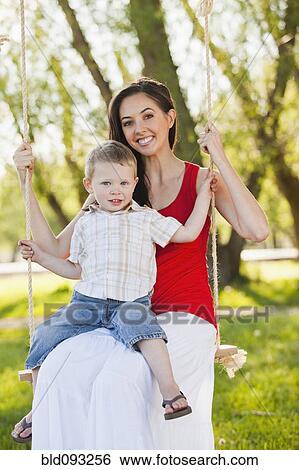 Caucasian mother and son swinging together View Large Photo Image Stock Photograph - Caucasian mother and son swinging together. Fotosearch