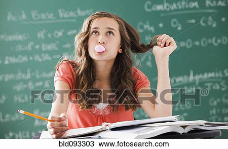 Stock Image - Caucasian teenager daydreaming in classroom. Fotosearch