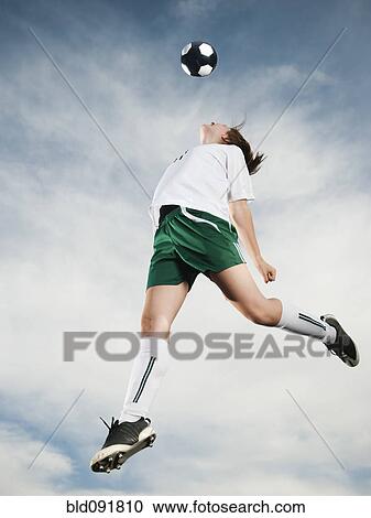 Caucasian teenager heading soccer ball in mid-air View Large Photo Image Stock Image - Caucasian teenager heading soccer ball in mid-air. Fotosearch
