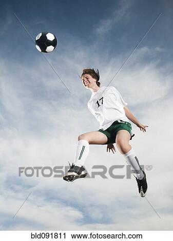 Caucasian teenager heading soccer ball in mid-air View Large Photo Image Stock Image - Caucasian teenager heading soccer ball in mid-air. Fotosearch