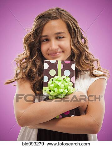 Stock Photo - Caucasian teenager holding gift. Fotosearch