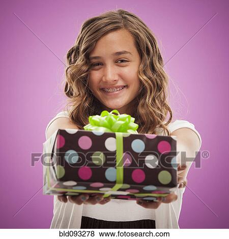 Caucasian teenager holding out gift View Large Photo Image Stock Photo - Caucasian teenager holding out gift. Fotosearch