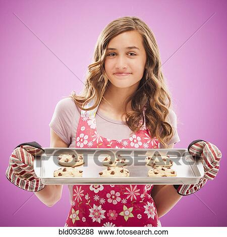Stock Photo - Caucasian teenager holding tray of fresh cookies. Fotosearch