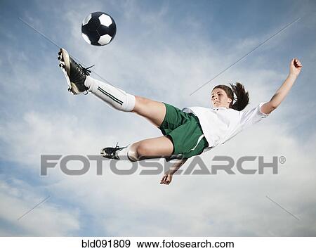 Caucasian teenager kicking soccer ball in mid-air View Large Photo Image Stock Photo - Caucasian teenager kicking soccer ball in mid-air. Fotosearch