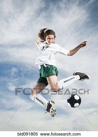 Caucasian teenager kicking soccer ball in mid-air View Large Photo Image Stock Photography - Caucasian teenager kicking soccer ball in mid-air. Fotosearch