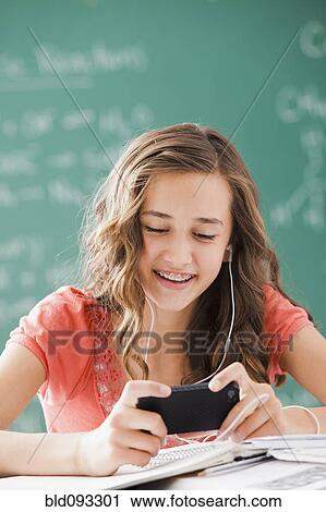 Caucasian teenager listening to mp3 player in classroom View Large Photo Image Stock Image - Caucasian teenager listening to mp3 player in classroom. Fotosearch