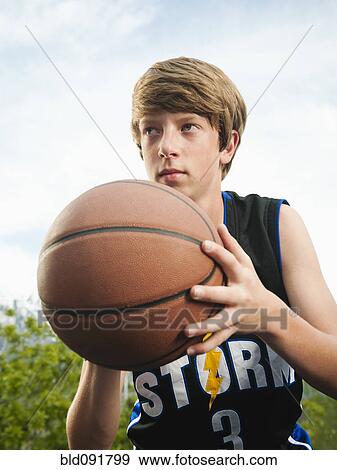 Stock Photo - Caucasian teenager playing basketball. Fotosearch